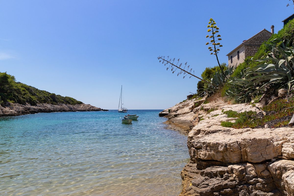 Klarte türkisblaue Bucht mit kleinen Booten an felsiger kroatischer Küste