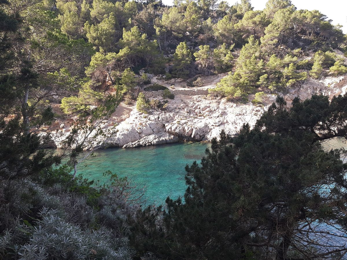 Türkisfarbenes Wasser einer abgelegenen Mittelmeerbucht mit felsigen Klippen