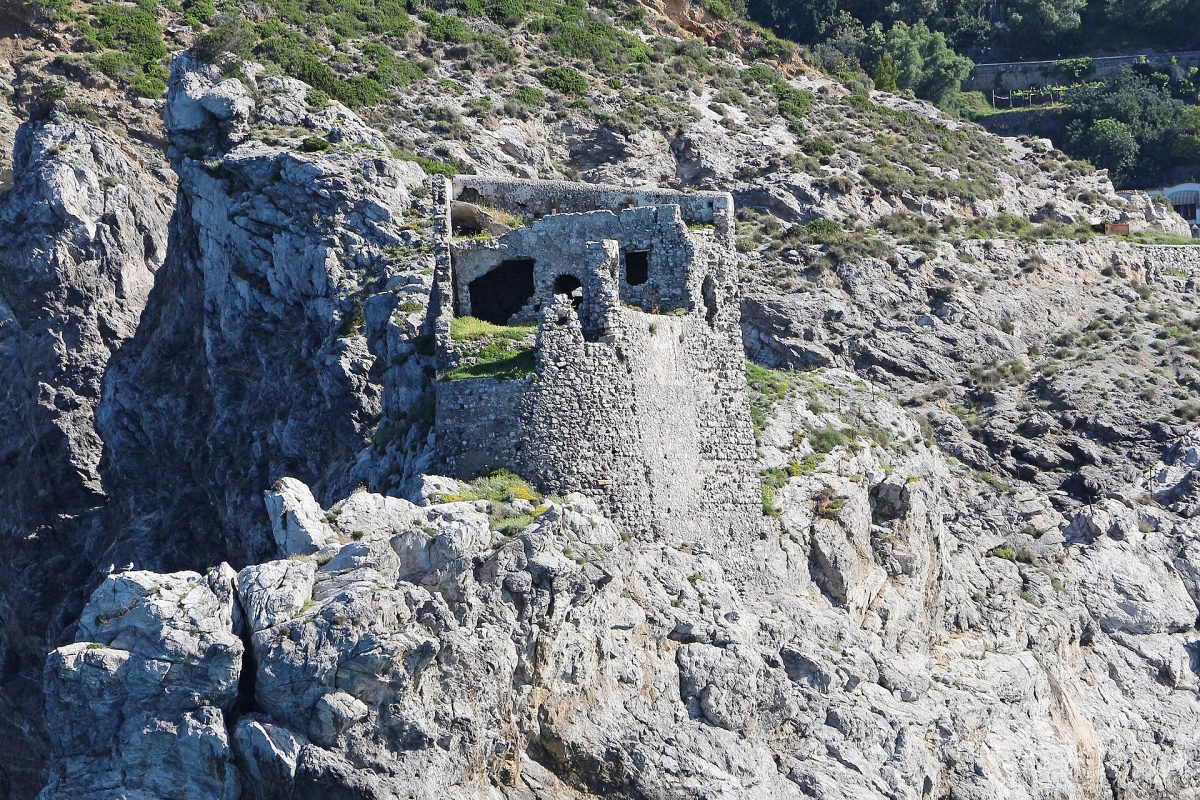 Ancient stone watchtower ruin perched on a steep rocky coastline