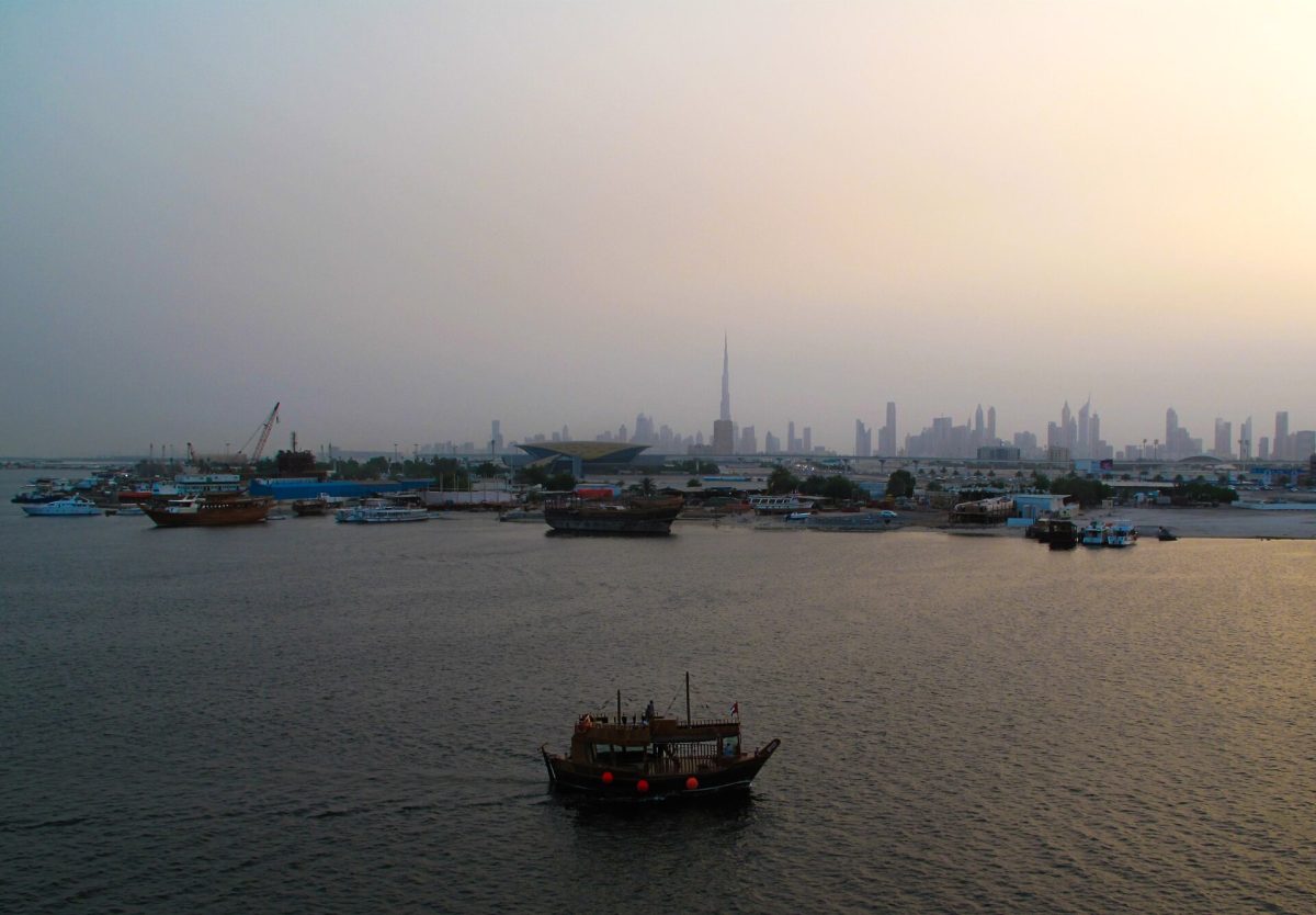 Traditional dhow boat sailing on Dubai Creek at sunset